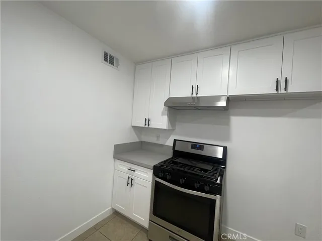a kitchen with granite countertop white cabinets and stainless steel appliances