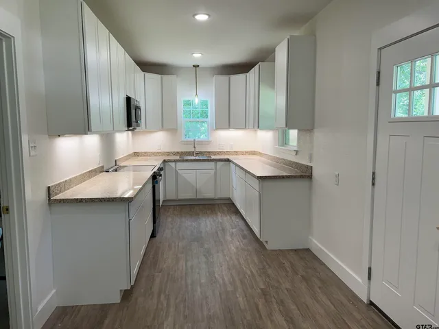 a kitchen with center island white cabinets and stainless steel appliances