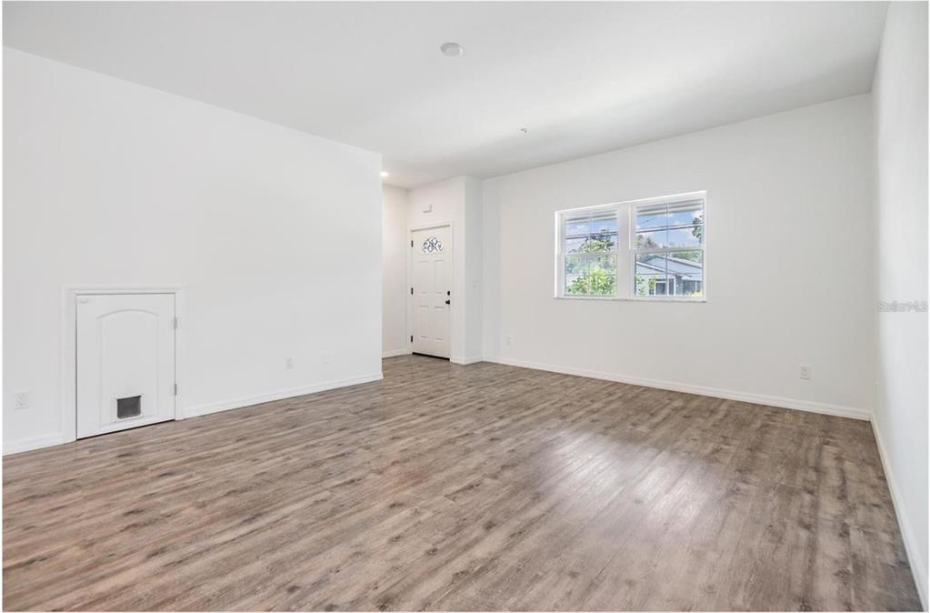 1264 Pierce Street Clearwater, FL 33756 - Photo 4 of 16 an empty room with wooden floor and windows