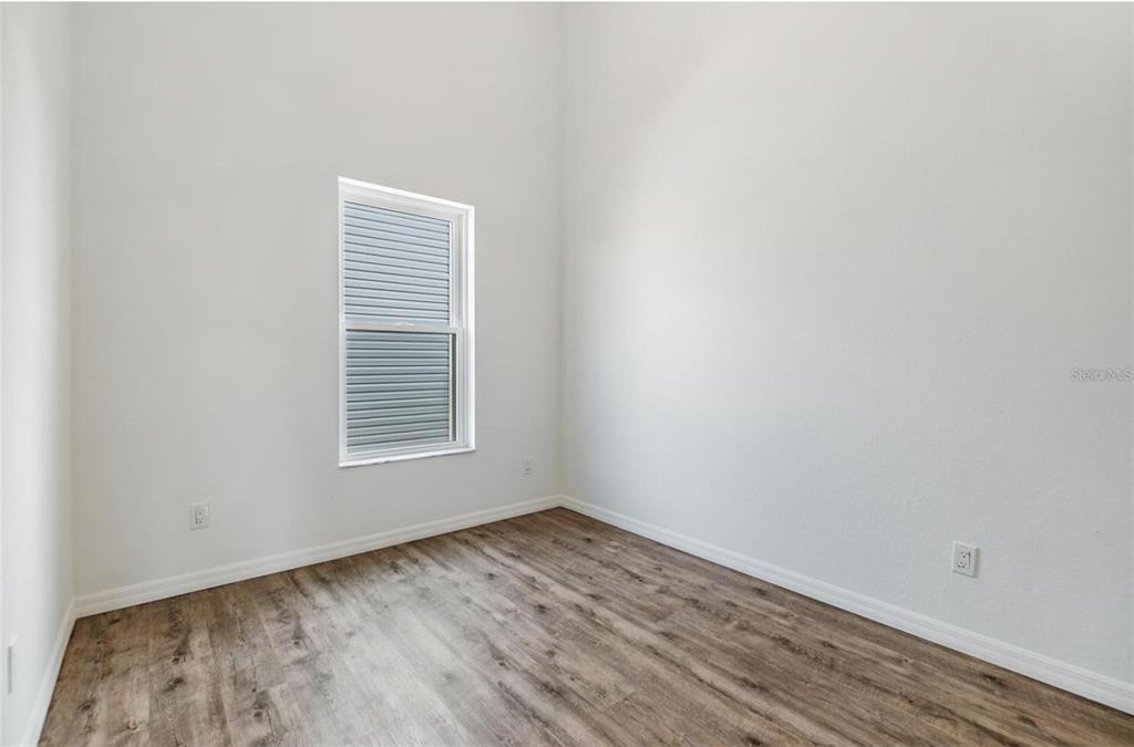 1264 Pierce Street Clearwater, FL 33756 - Photo 10 of 16 a view of an empty room with wooden floor and a window