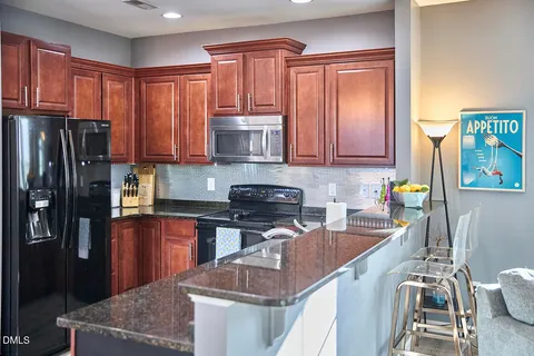 a kitchen with stainless steel appliances granite countertop a refrigerator sink and stove