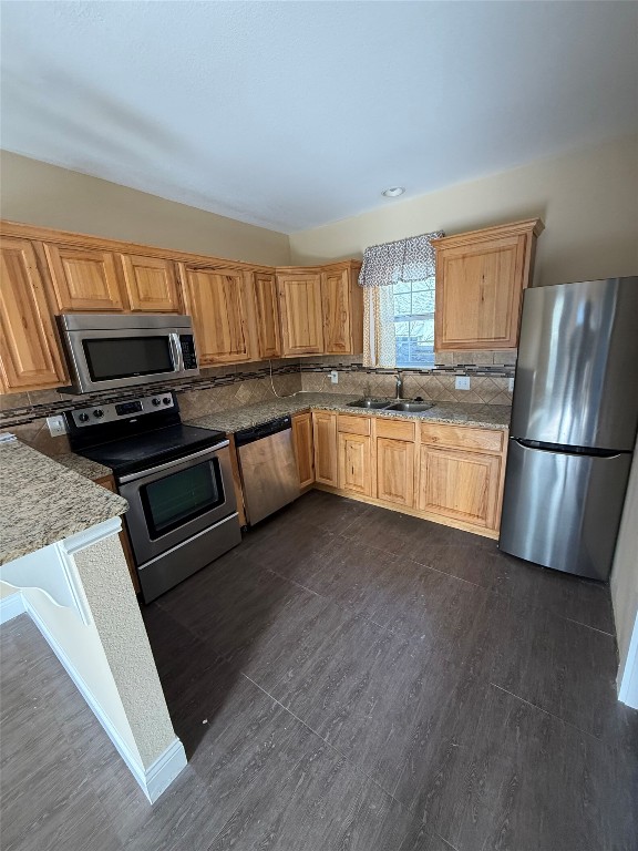 1313 Delano Street Austin, TX 78721 - Photo 10 of 32 Kitchen with stainless steel appliances, light stone counters, and decorative backsplash