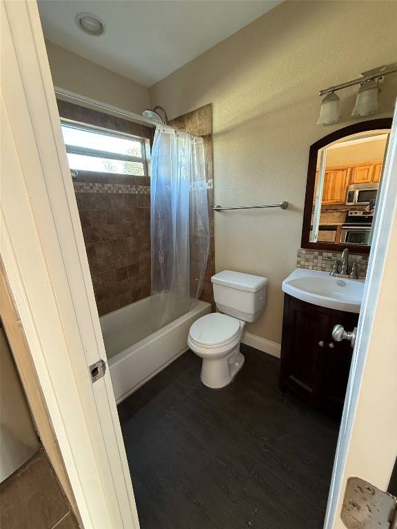 1313 Delano Street Austin, TX 78721 - Photo 11 of 32 Full bathroom with vanity, shower / bath combo, dark wood finished floors, and a textured wall