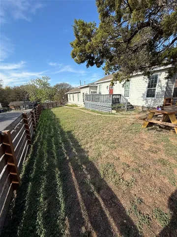a view of a yard with plants and trees