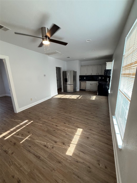 1313 Delano Street Austin, TX 78721 - Photo 3 of 32 Unfurnished living room featuring dark wood-style flooring and a ceiling fan