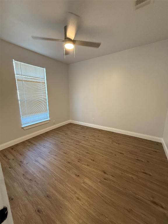 1313 Delano Street Austin, TX 78721 - Photo 6 of 32 Unfurnished room featuring dark wood-style flooring and a ceiling fan