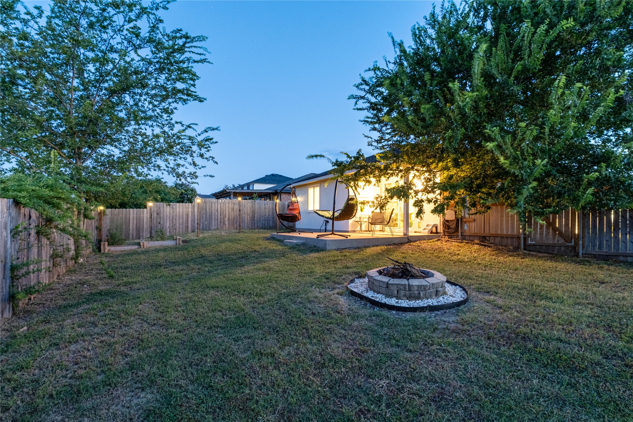 102 Woodley Road Leander, TX 78641 - Photo 19 of 24 a view of a backyard with table and chairs and a fire pit