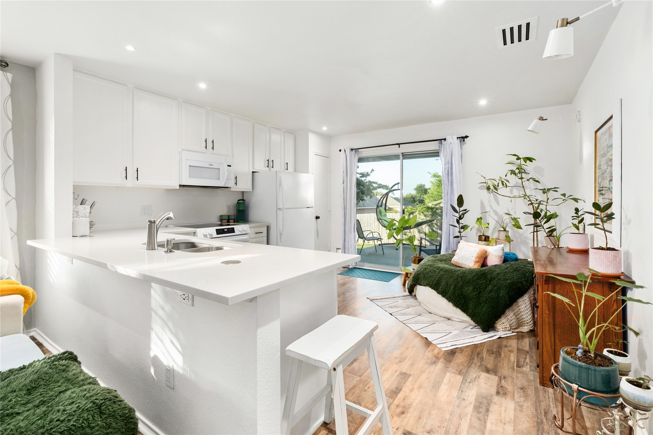 102 Woodley Road Leander, TX 78641 - Photo 5 of 24 a living room with stainless steel appliances kitchen island granite countertop furniture a rug a potted plant and a window
