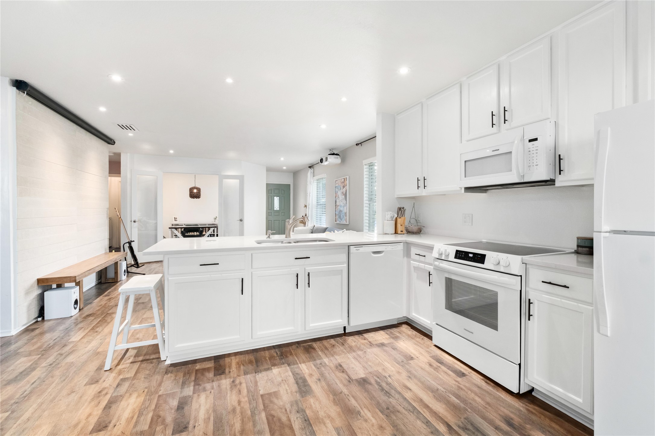 102 Woodley Road Leander, TX 78641 - Photo 7 of 24 a kitchen with white cabinets stainless steel appliances and wooden floor