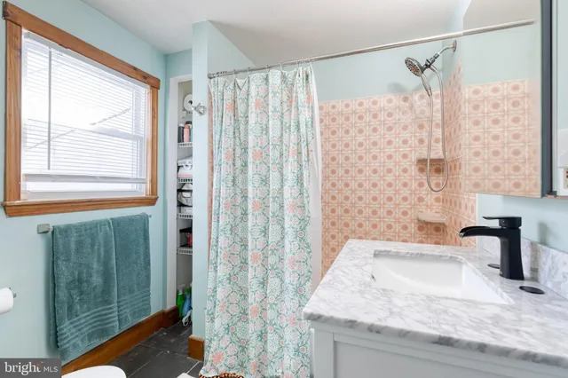 a bathroom with a granite countertop sink a shower and a mirror