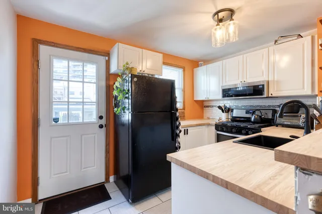 a kitchen with a refrigerator a microwave and sink