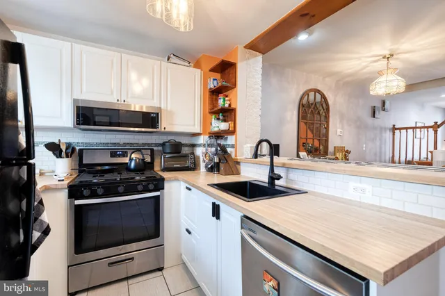 a kitchen with stainless steel appliances granite countertop a stove and a sink