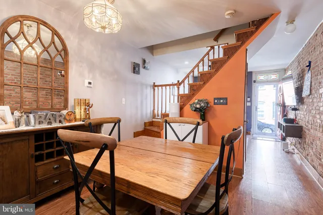 a dining room with furniture a chandelier and wooden floor