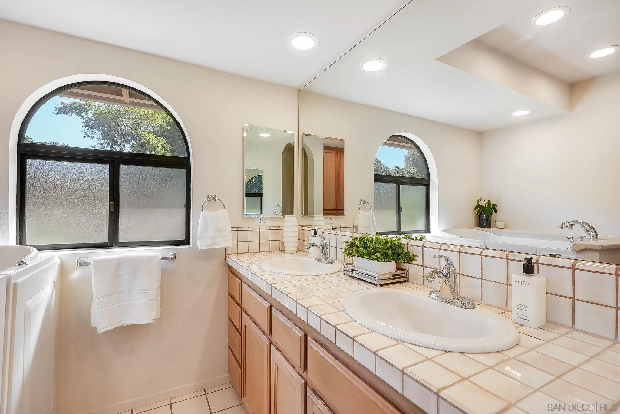 16456 Martincoit Road Poway, CA 92064 - Photo 31 of 55 a bathroom with a double vanity sink and a large mirror