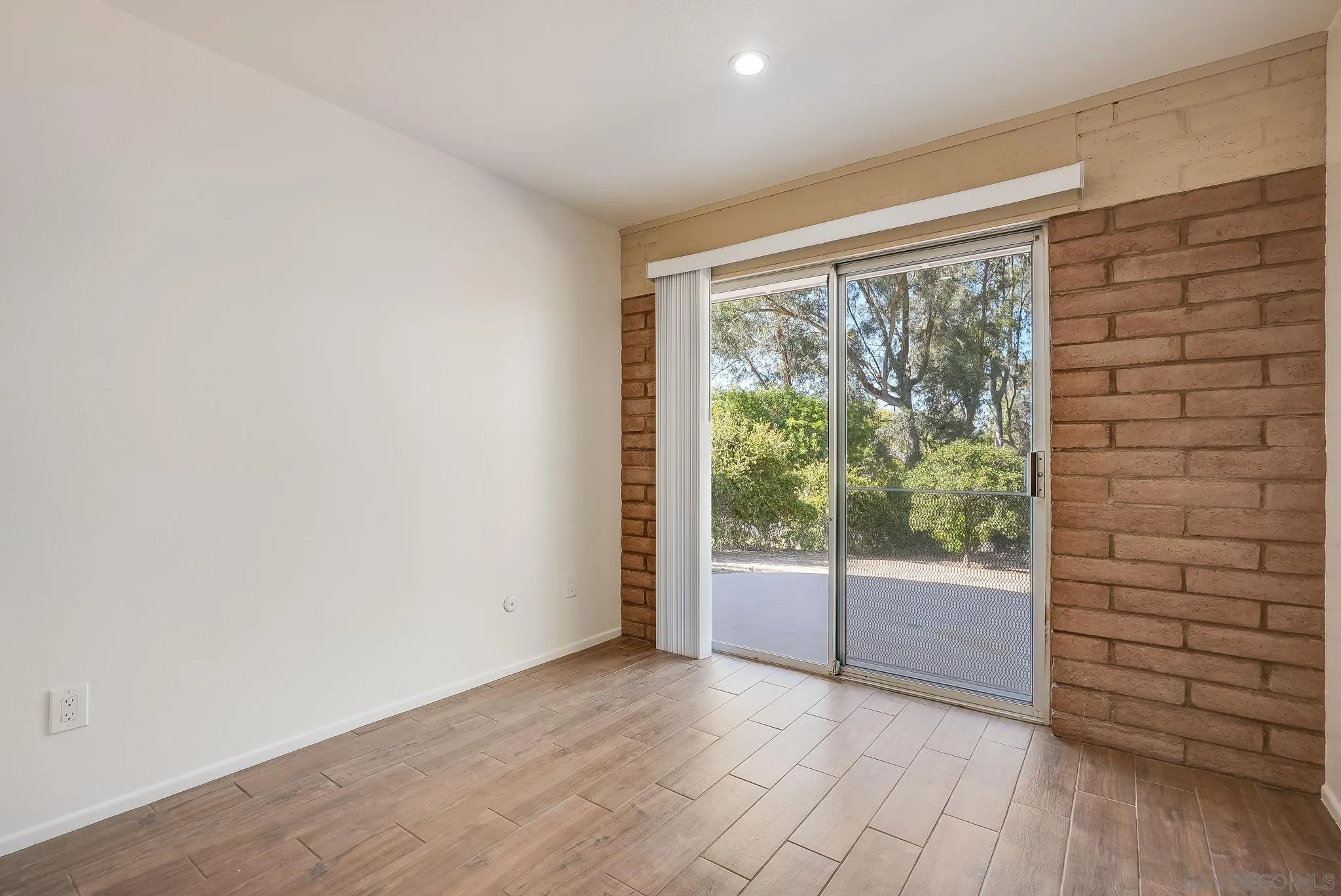 16456 Martincoit Road Poway, CA 92064 - Photo 45 of 55 an empty room with wooden floor and sliding door