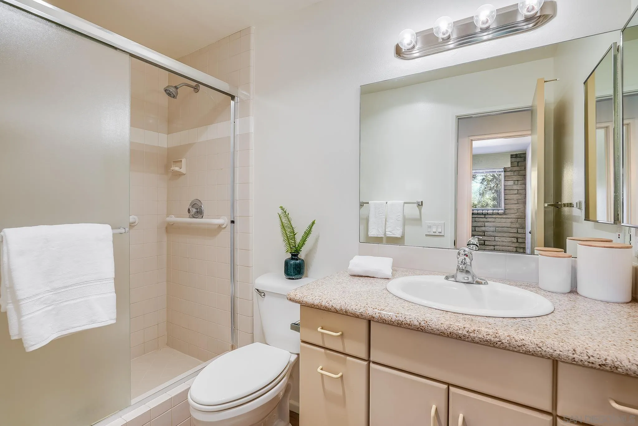 16456 Martincoit Road Poway, CA 92064 - Photo 50 of 55 a bathroom with a granite countertop sink a toilet a mirror and shower