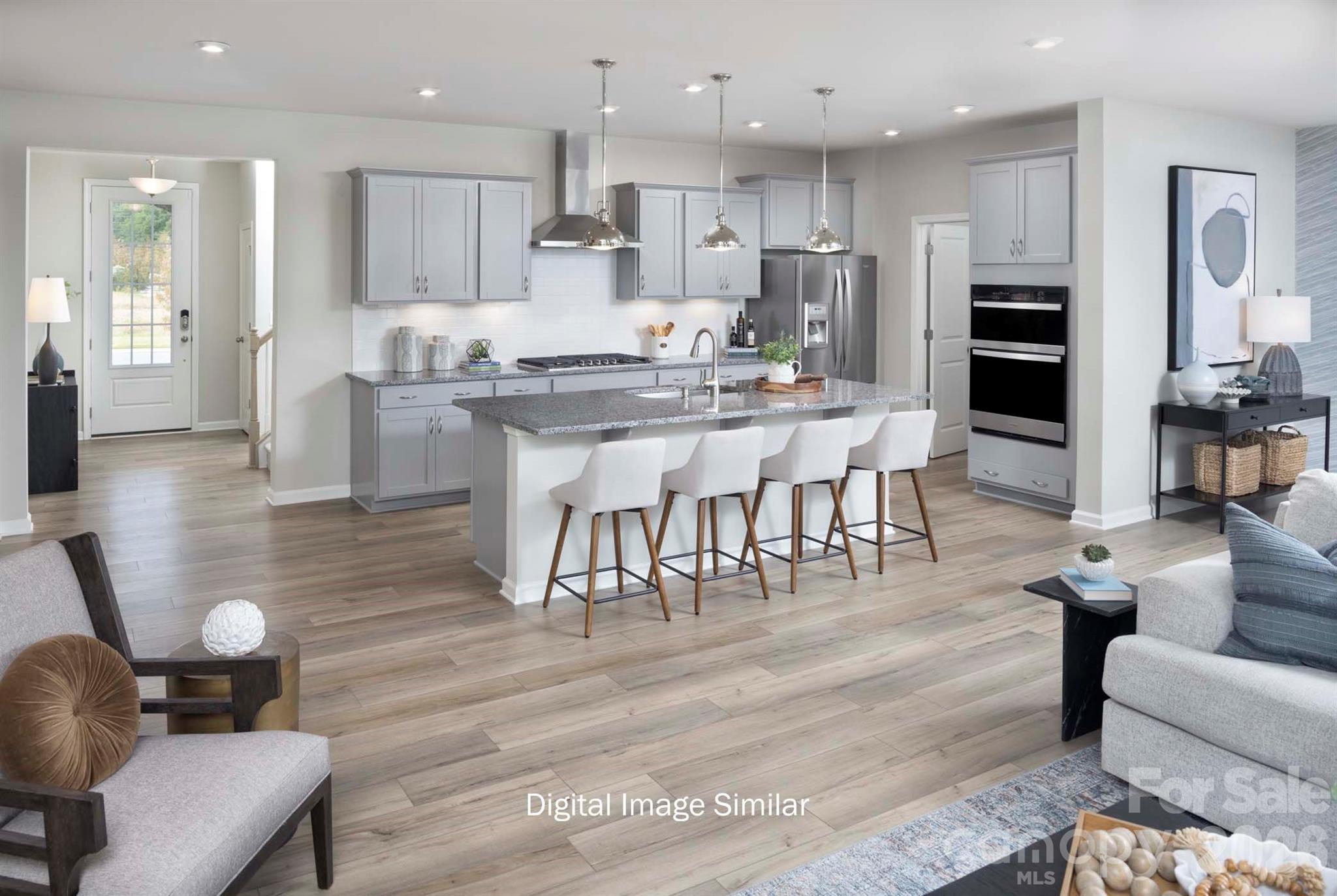 2550 Mabel Lane Monroe, NC 28110 - Photo 21 of 25 a kitchen with stainless steel appliances kitchen island granite countertop a table chairs and a living room view