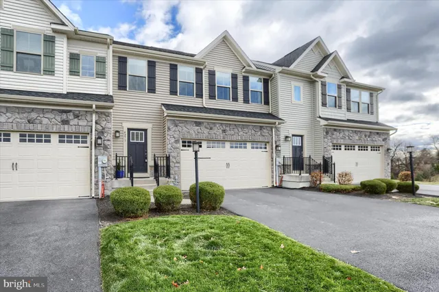 a view of a white house with large windows and a small yard