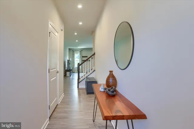 a kitchen with stainless steel appliances granite countertop a refrigerator a stove a sink a dining table and chairs with wooden floor