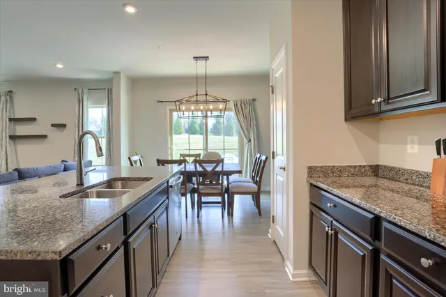 a kitchen with stainless steel appliances granite countertop a sink a stove and a refrigerator