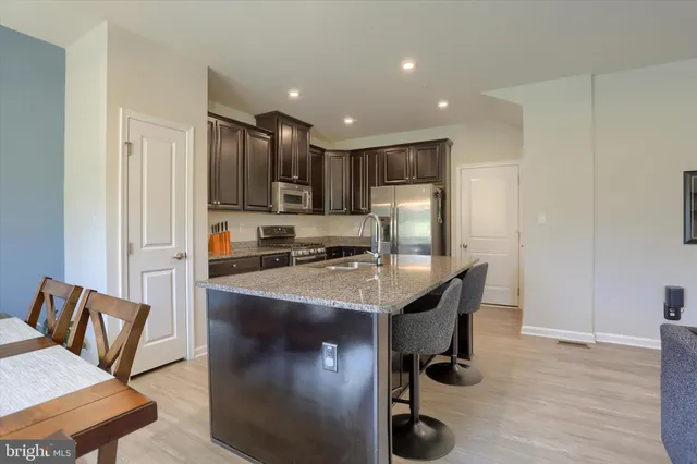 a view of a dining room and livingroom with furniture wooden floor a chandelier