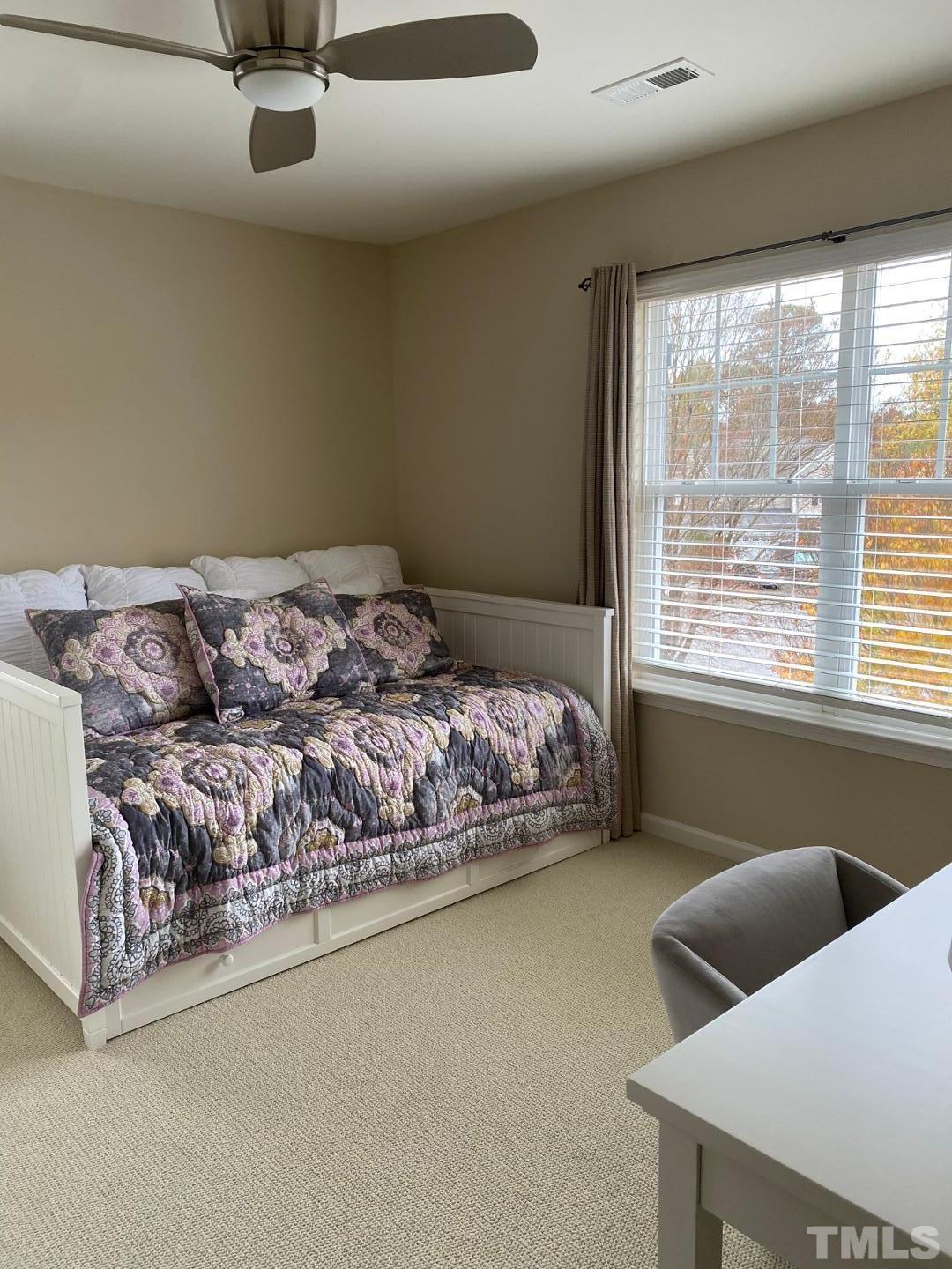 6006 McDevon Drive Raleigh, NC 27617 - Photo 9 of 12 a bed sitting in a bedroom next to a window