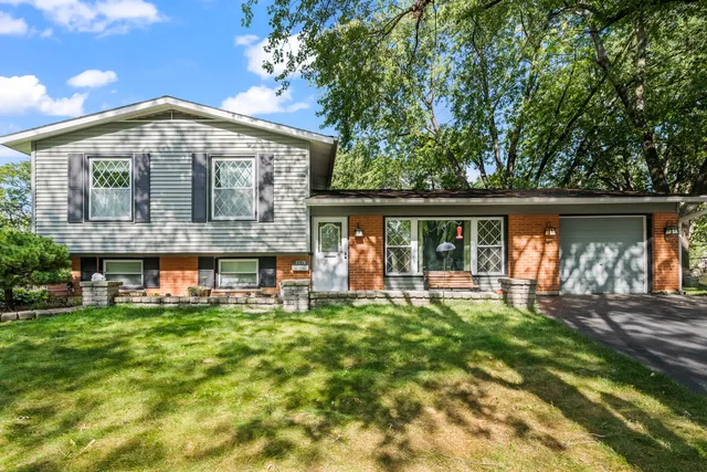 a view of a house with a yard and sitting area