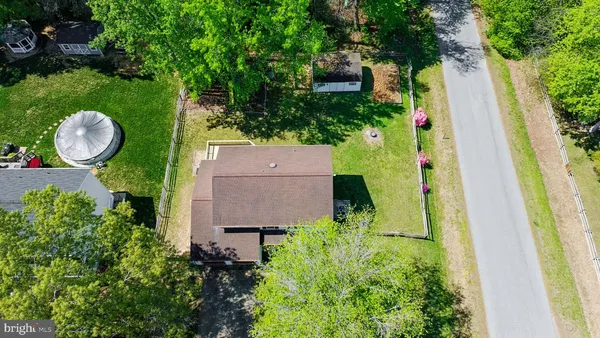 an aerial view of a house with a yard and greenery
