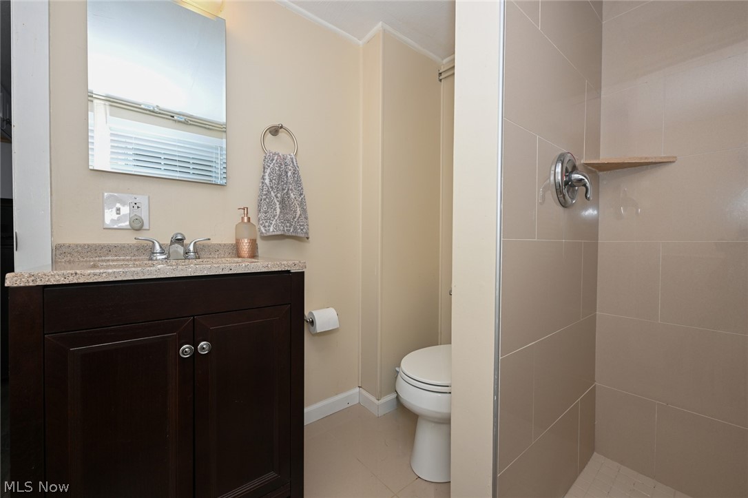 24481 Barrett Road Olmsted Falls, OH 44138 - Photo 41 of 49 Bathroom featuring a tile shower, tile floors, toilet, and vanity