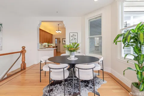 a living room with furniture a dining table and a potted plant