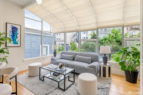 a view of a living room with furniture and wooden floor