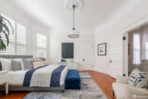 a spacious bedroom with a bed and a flat screen television