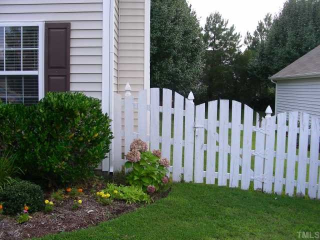 This picture shows the white fence which extends throughout the neighborhood. This is the gate to the back of house.