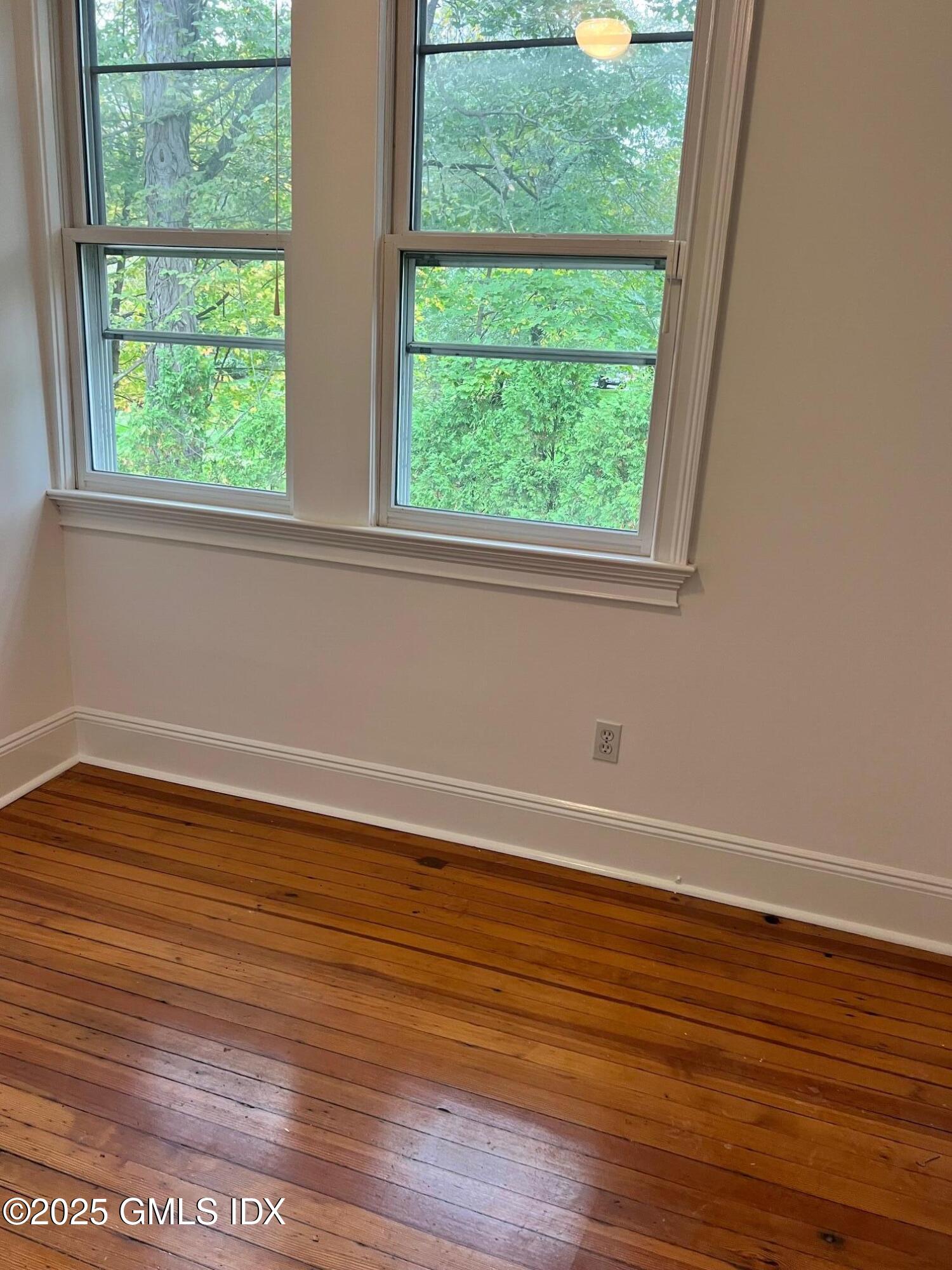 215 Old Church Road, Unit CARRIAGE HOUSE Greenwich, CT 06830 - Photo 10 of 14 a view of a big room with wooden floor and windows