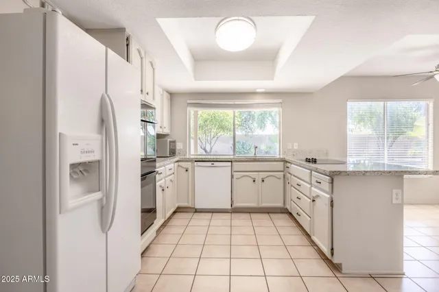 a kitchen with granite countertop appliances a sink and a refrigerator