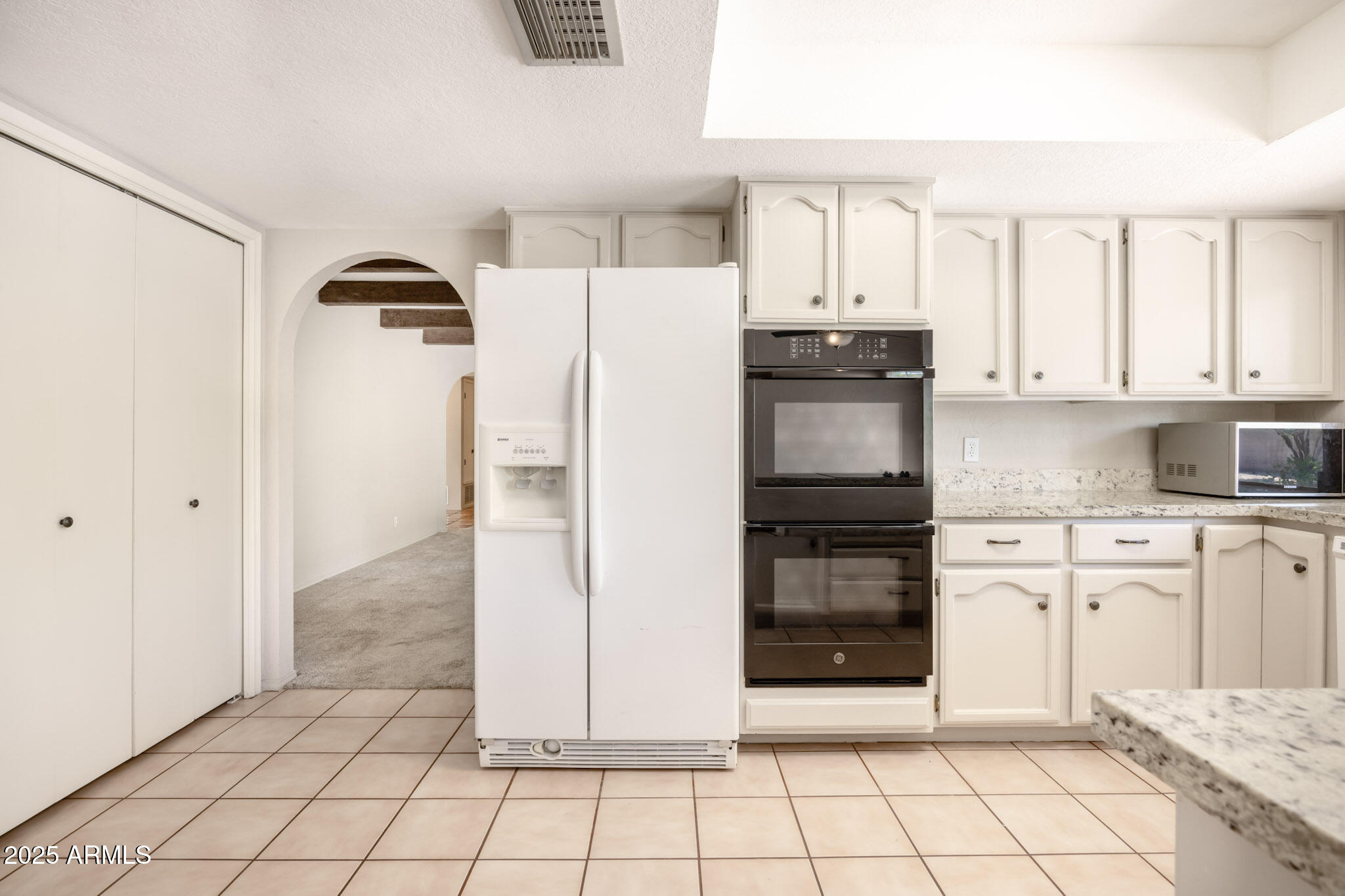 5701 East Sandy Lane Scottsdale, AZ 85254 - Photo 19 of 48 a kitchen with white cabinets and refrigerator
