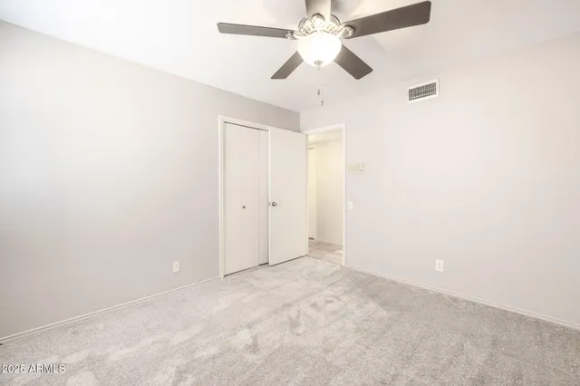 an empty room with a chandelier fan and closet in a kitchen