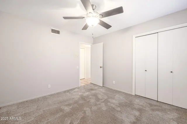 an empty room with fan and entryway