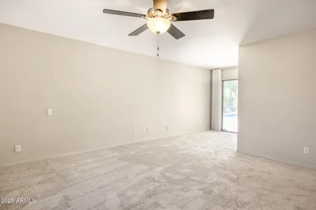 an empty room with a ceiling fan and a chandelier fan
