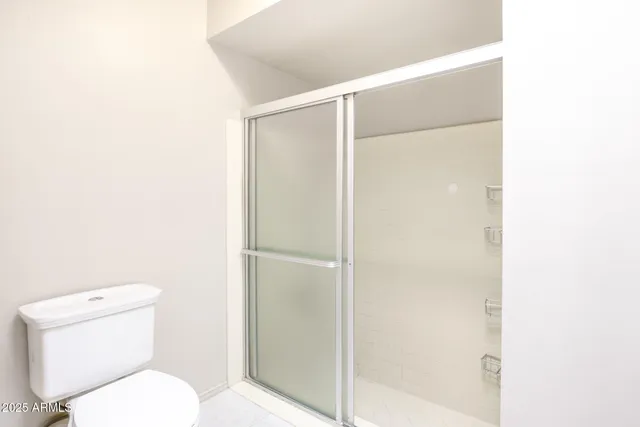 a white toilet sitting next to a shower