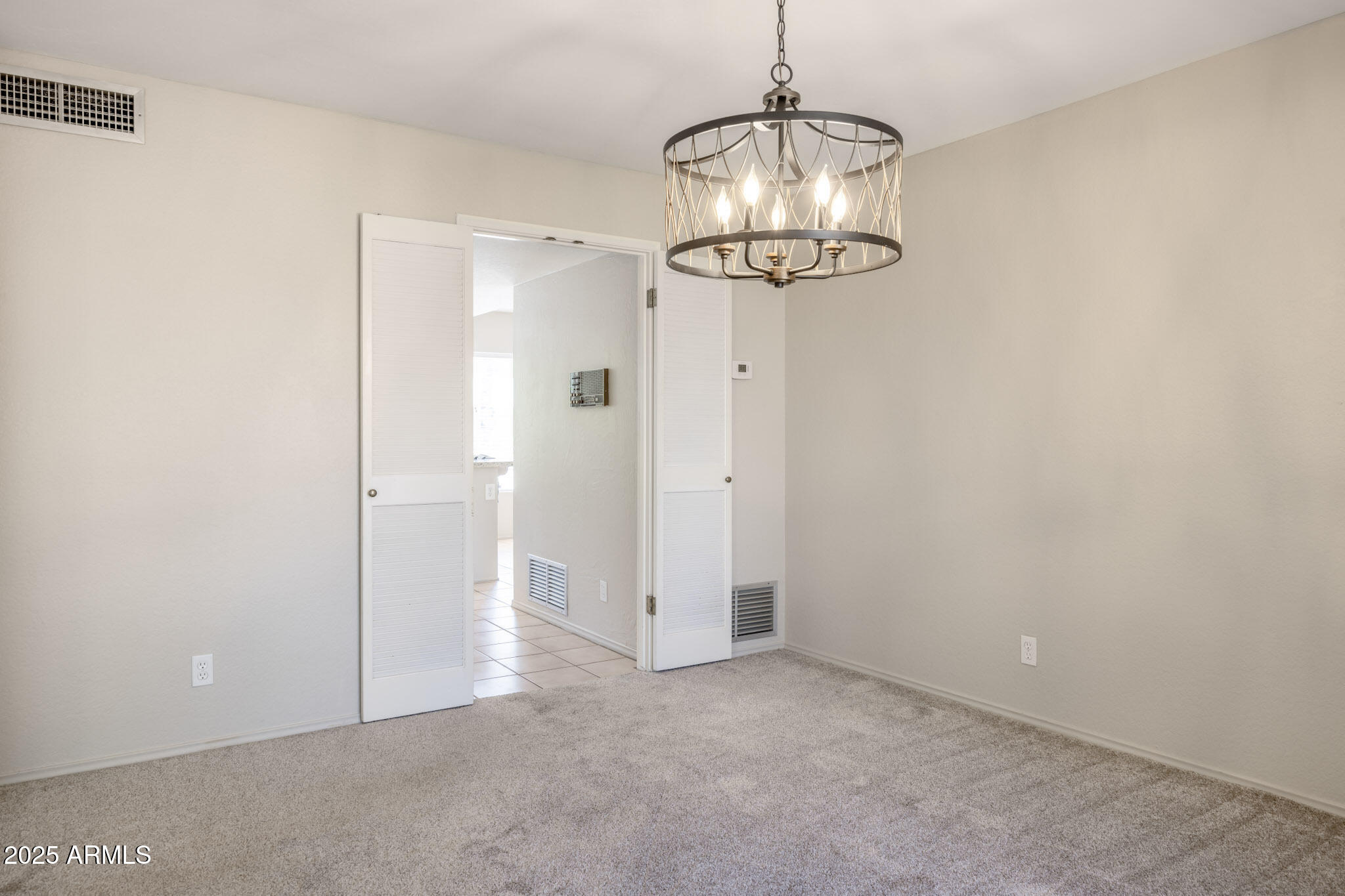 5701 East Sandy Lane Scottsdale, AZ 85254 - Photo 8 of 48 an empty room with a chandelier fan and wooden floor