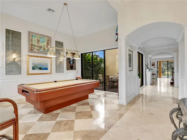 a room with pool table and glass windows