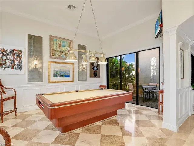 a room with pool table and windows