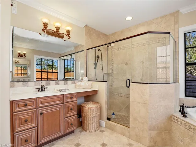 a bathroom with a granite countertop sink a mirror a shower and vanity