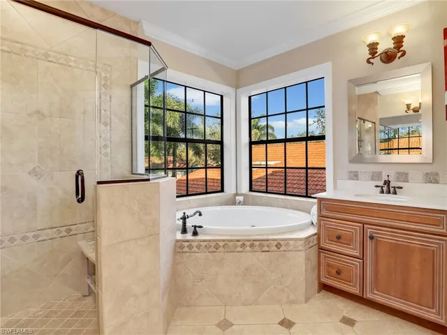 a spacious bathroom with a tub sink and mirror
