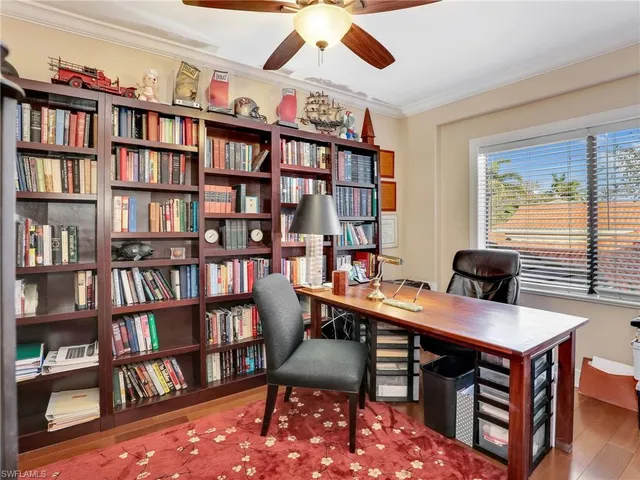 a view of a workspace with furniture and a bookshelf