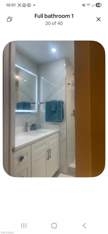 200 Turtle Lake Court, Unit 309 Naples, FL 34105 - Photo 12 of 17 a bathroom with a sink a mirror and a bathtub