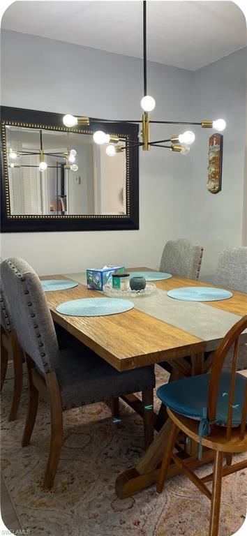 200 Turtle Lake Court, Unit 309 Naples, FL 34105 - Photo 2 of 17 a dining room with a table chairs and a kitchen view