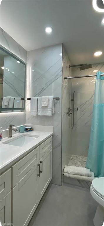 200 Turtle Lake Court, Unit 309 Naples, FL 34105 - Photo 10 of 17 a bathroom with a double vanity sink toilet and shower