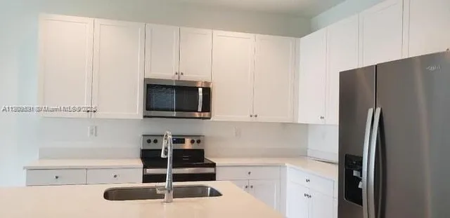 a kitchen with stainless steel appliances a refrigerator and cabinets